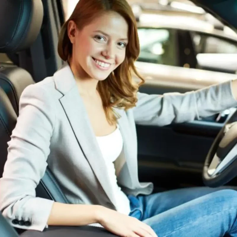 Mulher sorrindo ao volante após contratar proteção veicular da RB Protege.